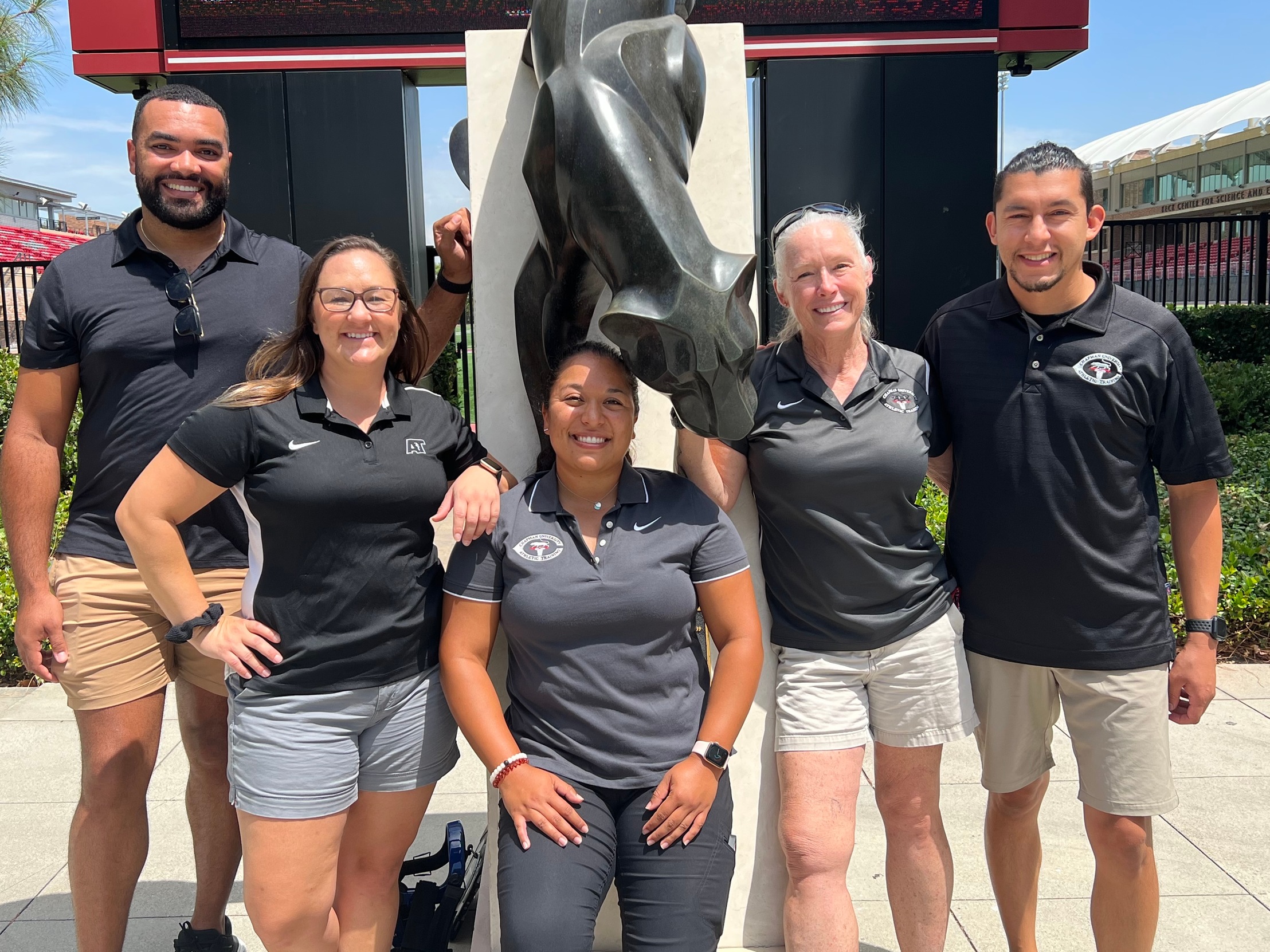 The five athletic trainers in front of the panther statue.