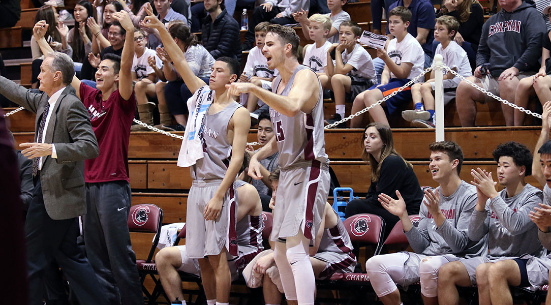 The Chapman bench cheers after a basket.