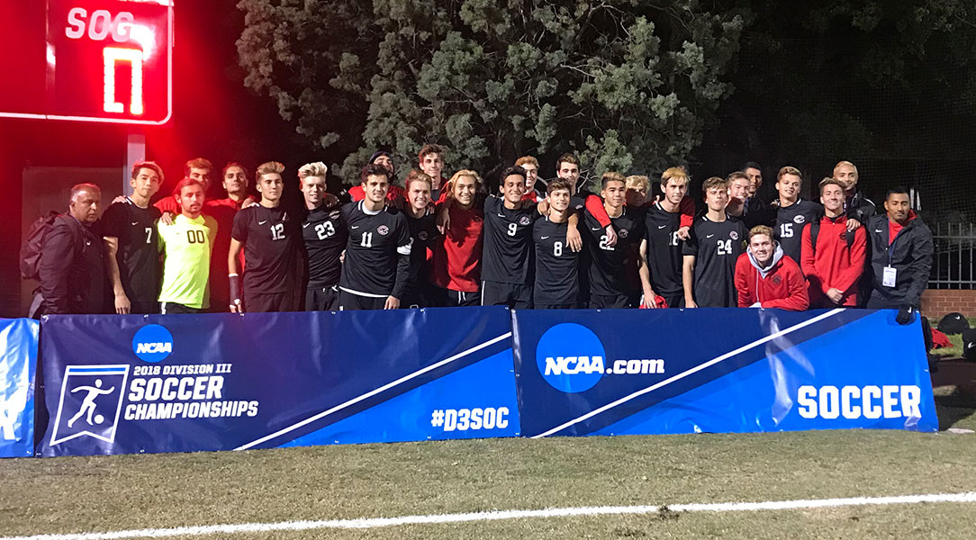 The Chapman men's soccer team poses in front of the NCAA signs.