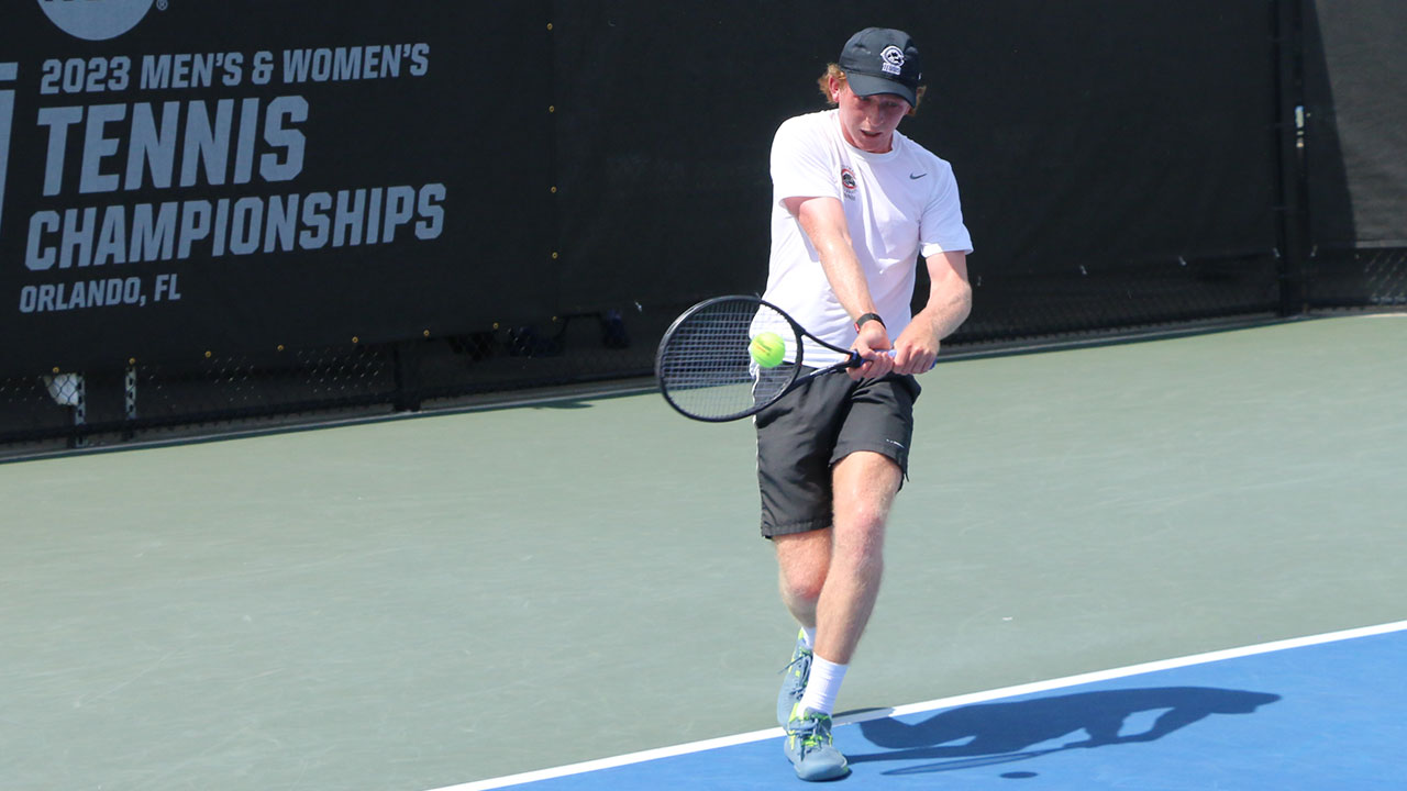 Caleb Wilkins hits a backhand winner from the baseline of the tennis court.