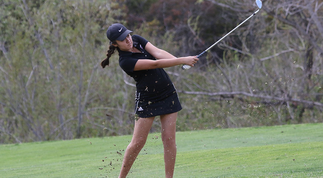 Emily Lewis swings the golf club.