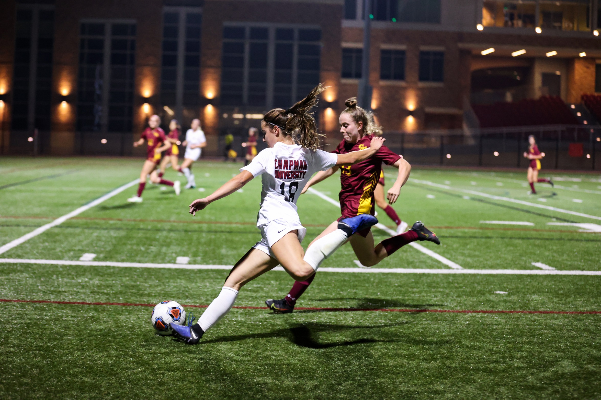 Chapman women's soccer player kicks soccer ball downfield 