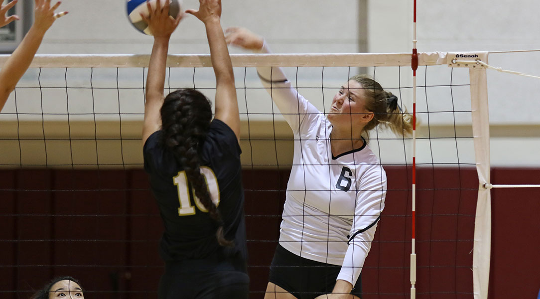 Jessi Lumsden jumps up to hit the ball over the net.