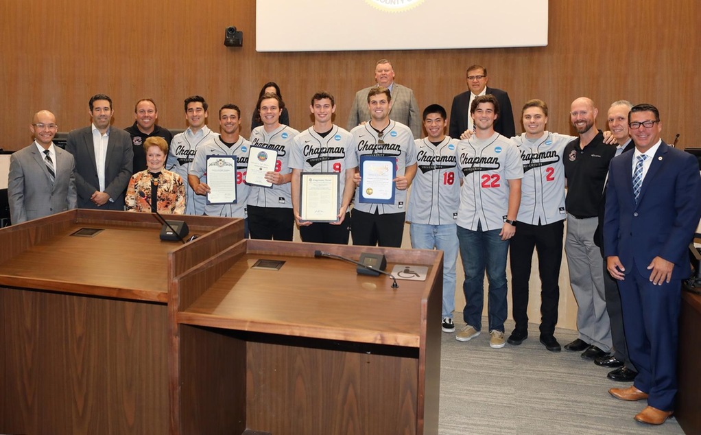 Members of the baseball team and representatives of local elected officals pose for a picture with the Orange City Council.
