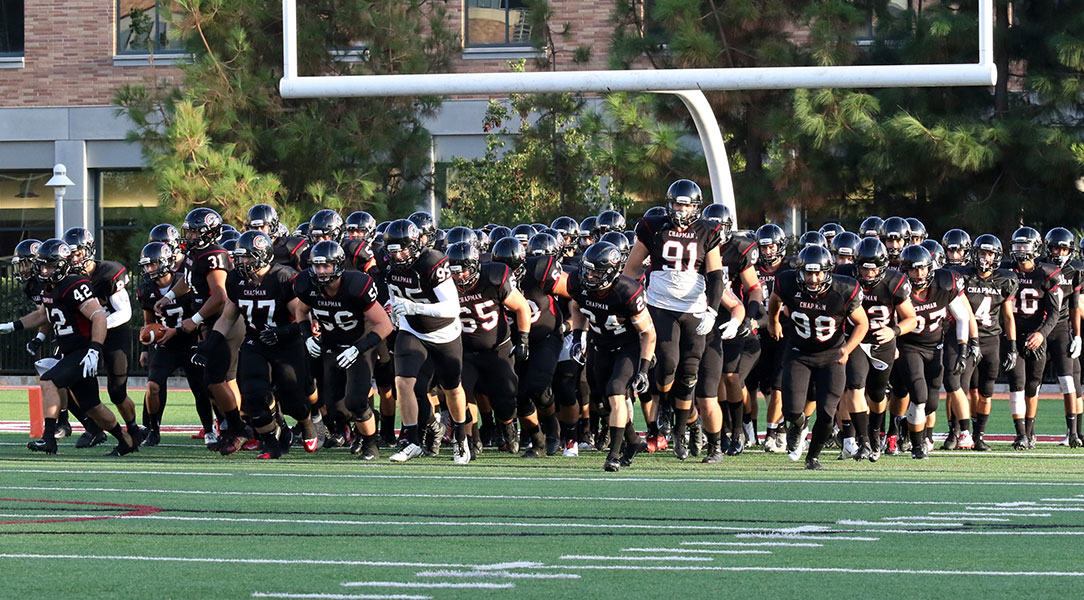 The football team runs on to the field.