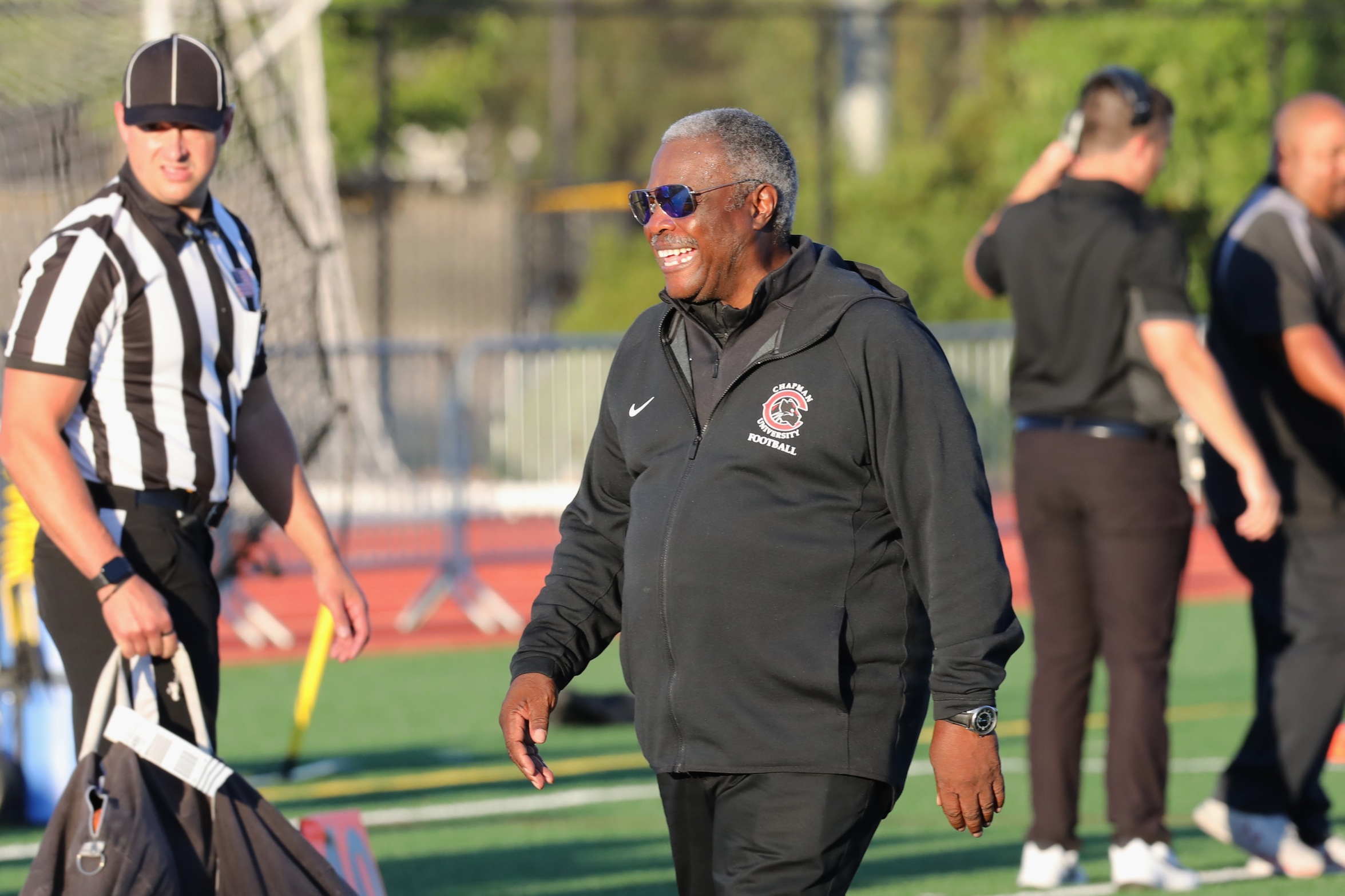 Head coach Bob Owens smile as he walks across field 