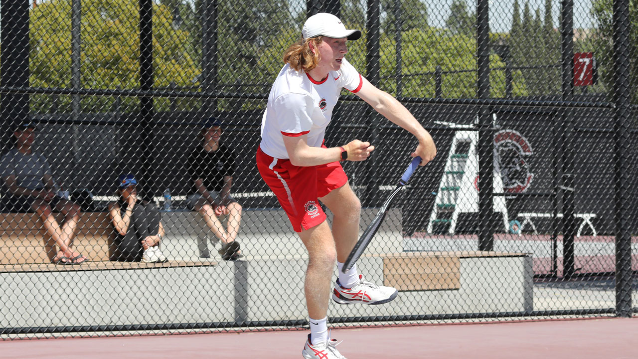 Caleb Wilkins serves in tennis.