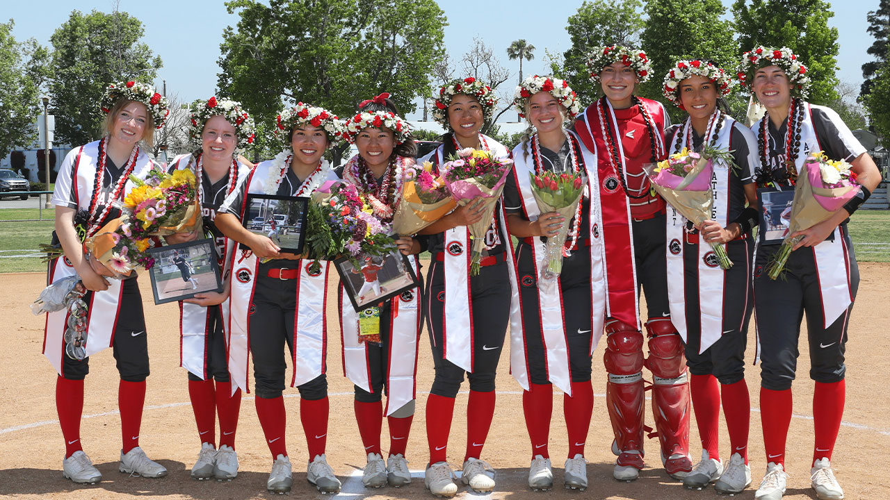 Nine Chapman softball seniors holding flowers.