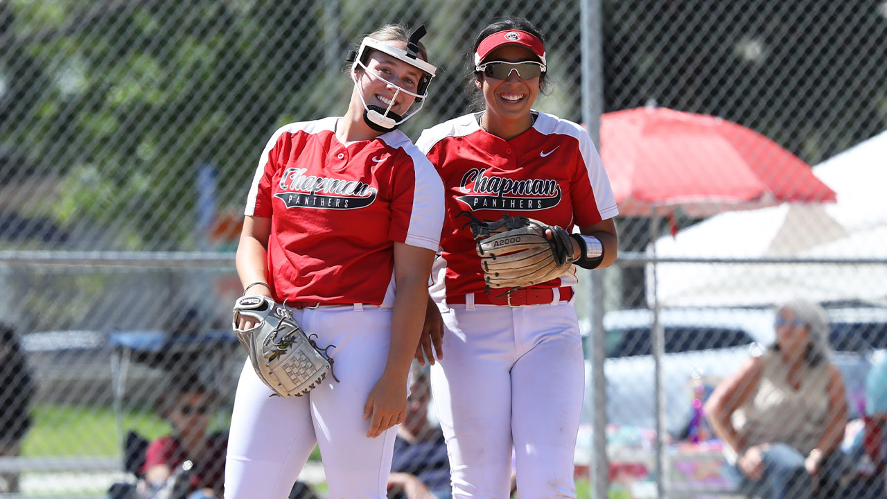 Jillian Kelly and Illiana Serna smile together before the start of an inning.