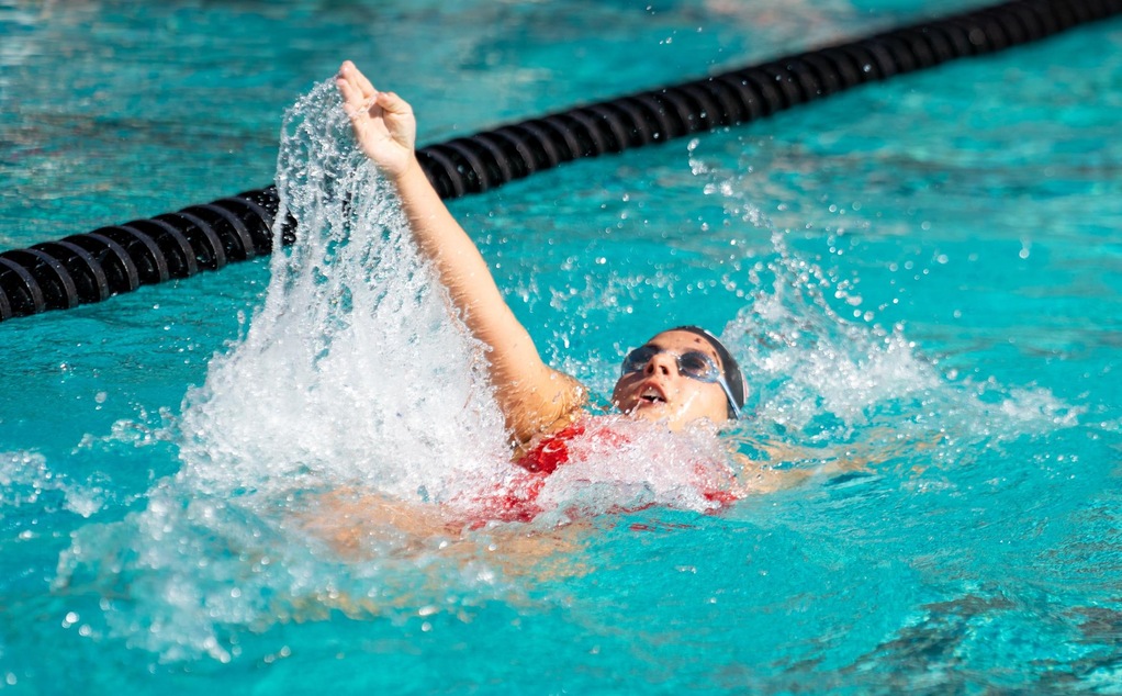 A Chapman women's swimmer doing the backstroke.