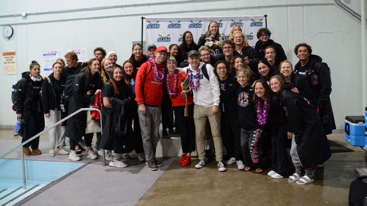 The coaches surrounded by swimmers on the pool deck after winning Coach of the Year.