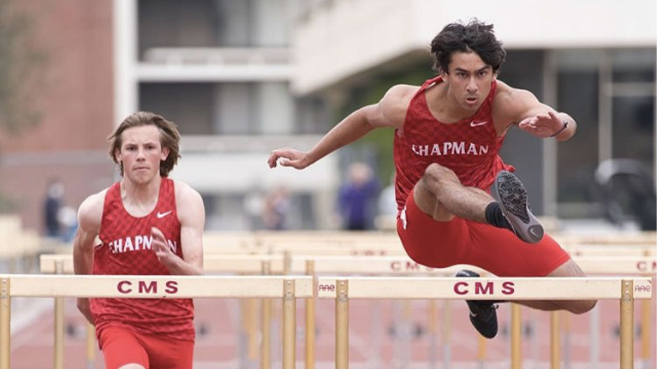 Chapman runner leaping over a hurdle.