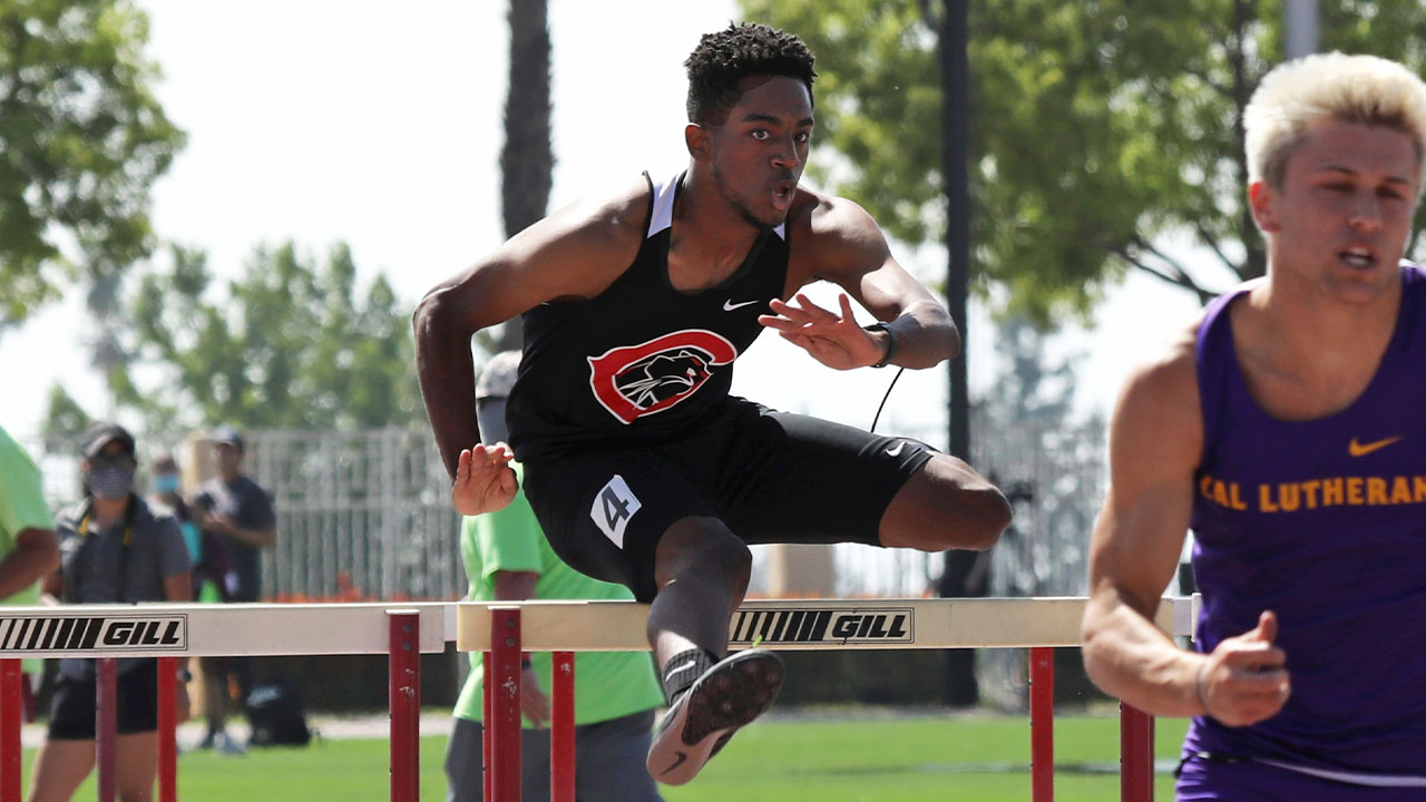 Michael Crumby jumps over a hurdle.