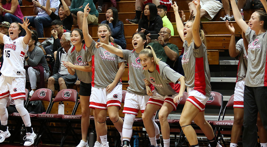 The Chapman bench celebrates after a three pointer.