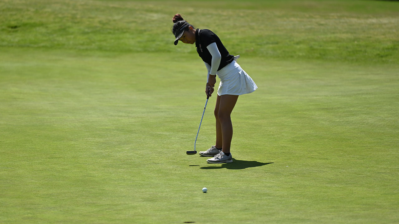 Emily Cho putting on the golf course.