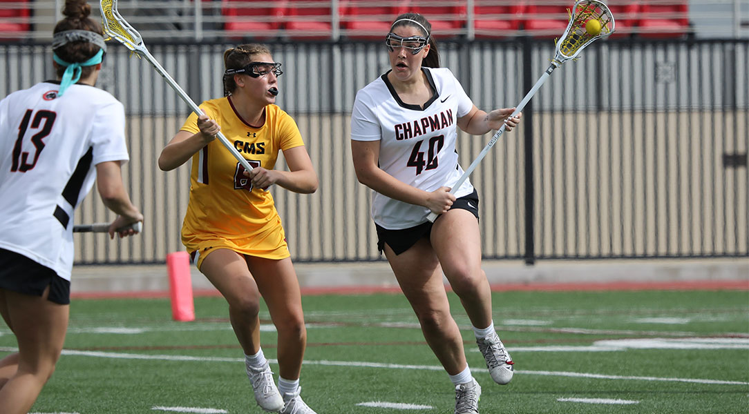 Aisling Roberts runs around a defender in lacrosse.