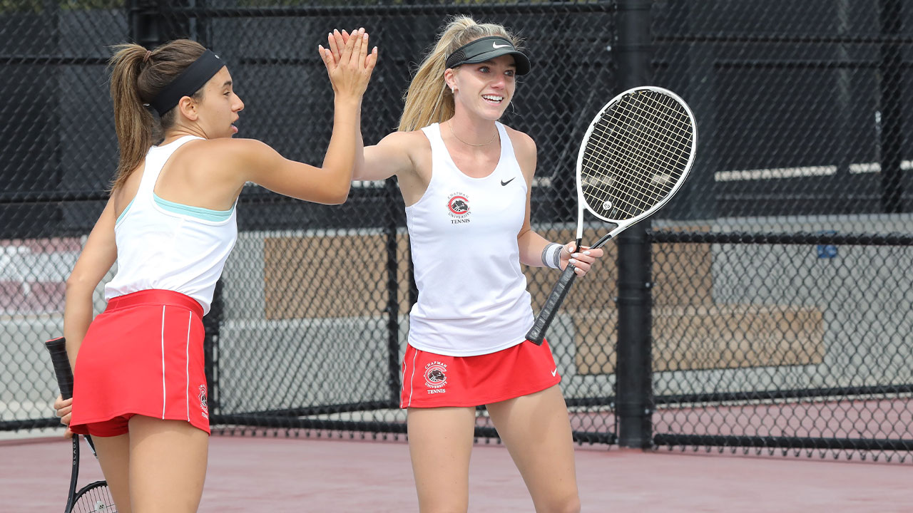 Aliya Allyn high-fives her tennis doubles partner teammate after winning a point.