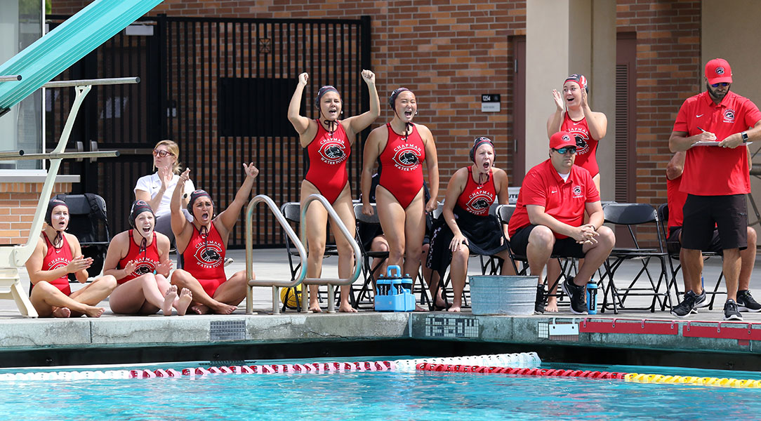 The women's water polo team cheers on the sideline.