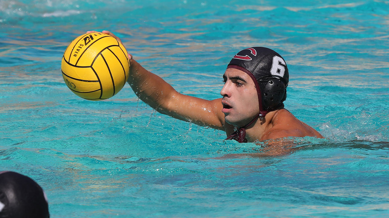 Andy Anguiano swims with a water polo ball.