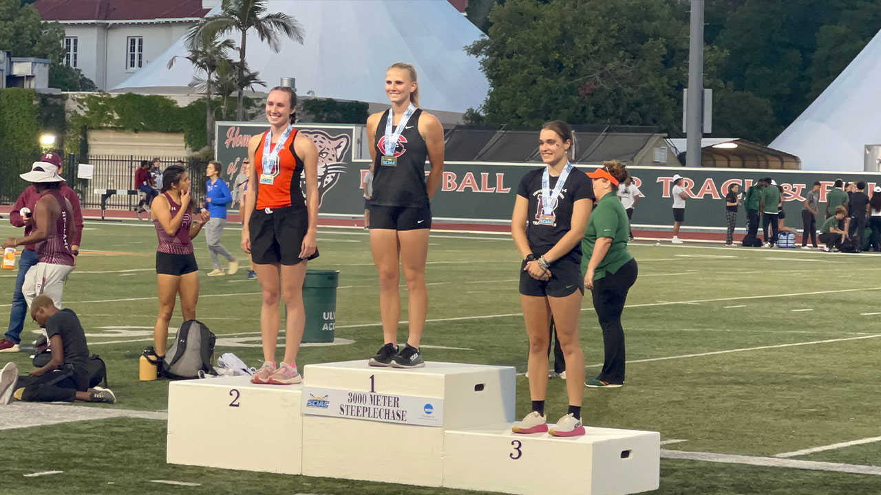 Annika Carlson stands on top of the podium.