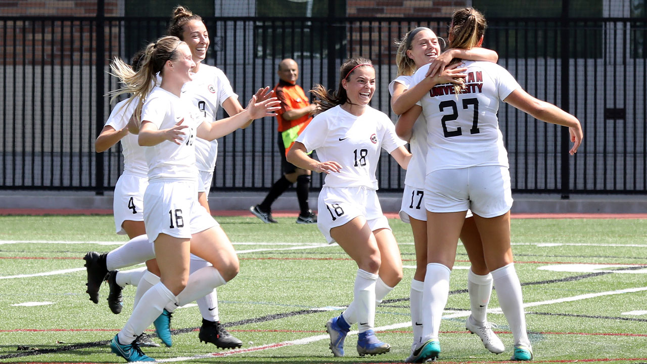 A group of players celebrate Riley Pidgeon's goal.